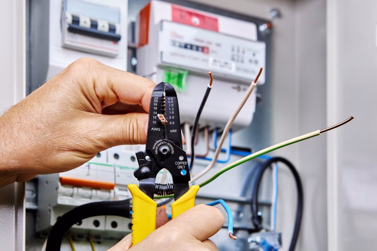 Image of someone cutting wires in electricity meter.